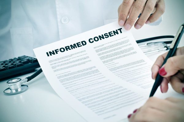 A clinical research participant signing an informed consent form.