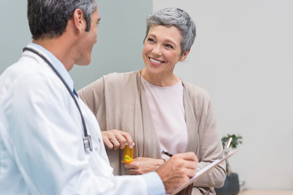 Woman talking with her doctor regarding her clinicial research study.